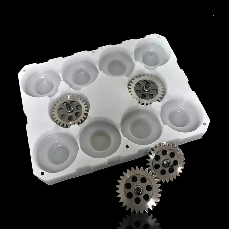 White thermoformed tray holding gears and components